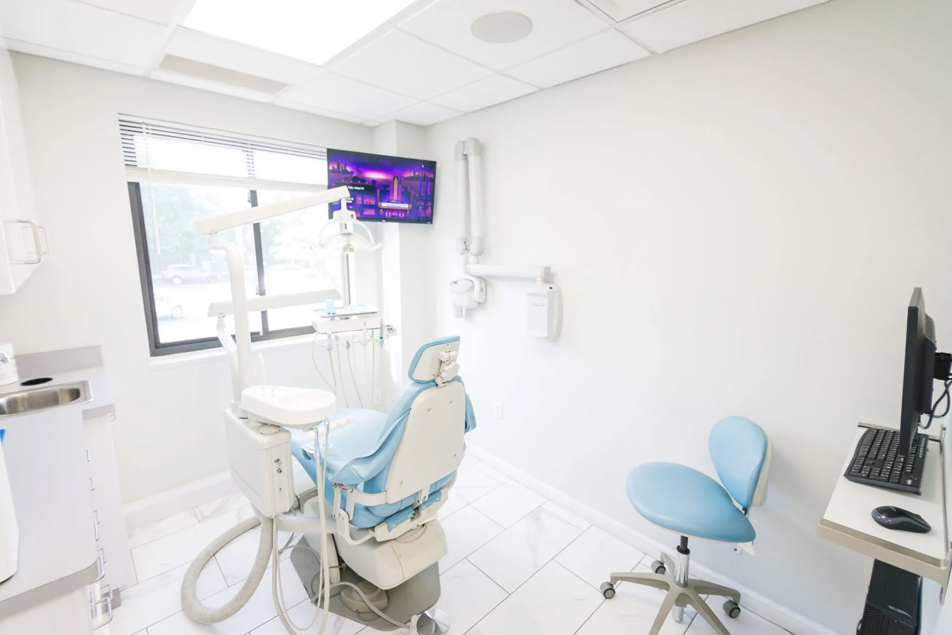 The image shows an interior view of a dental office, featuring dental equipment and a modern aesthetic.