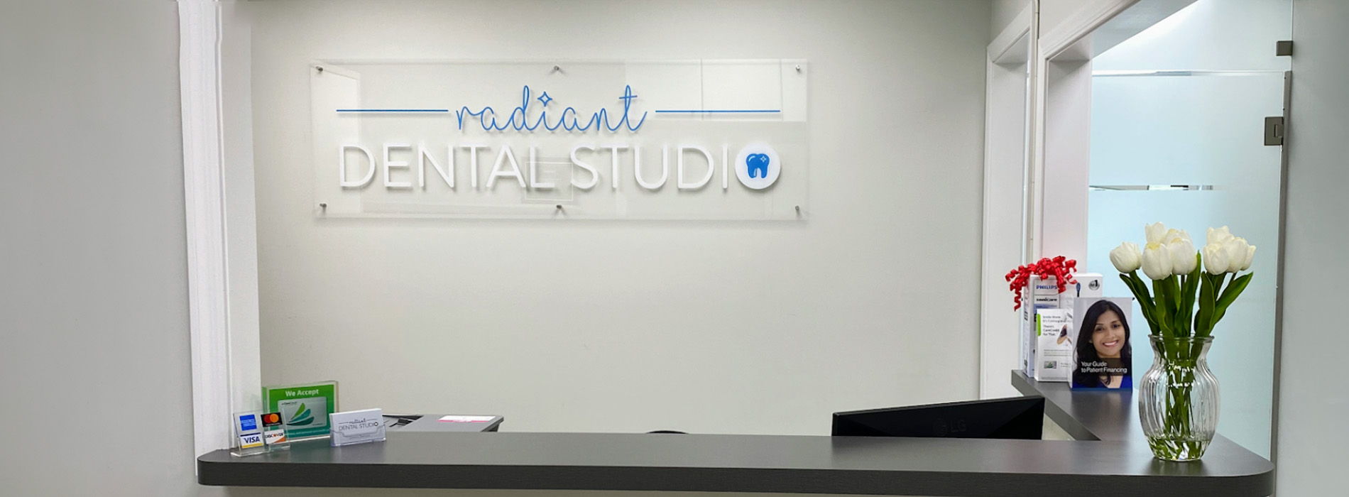 An image of a dental clinic reception area with a sign that reads  Radiant Dental .