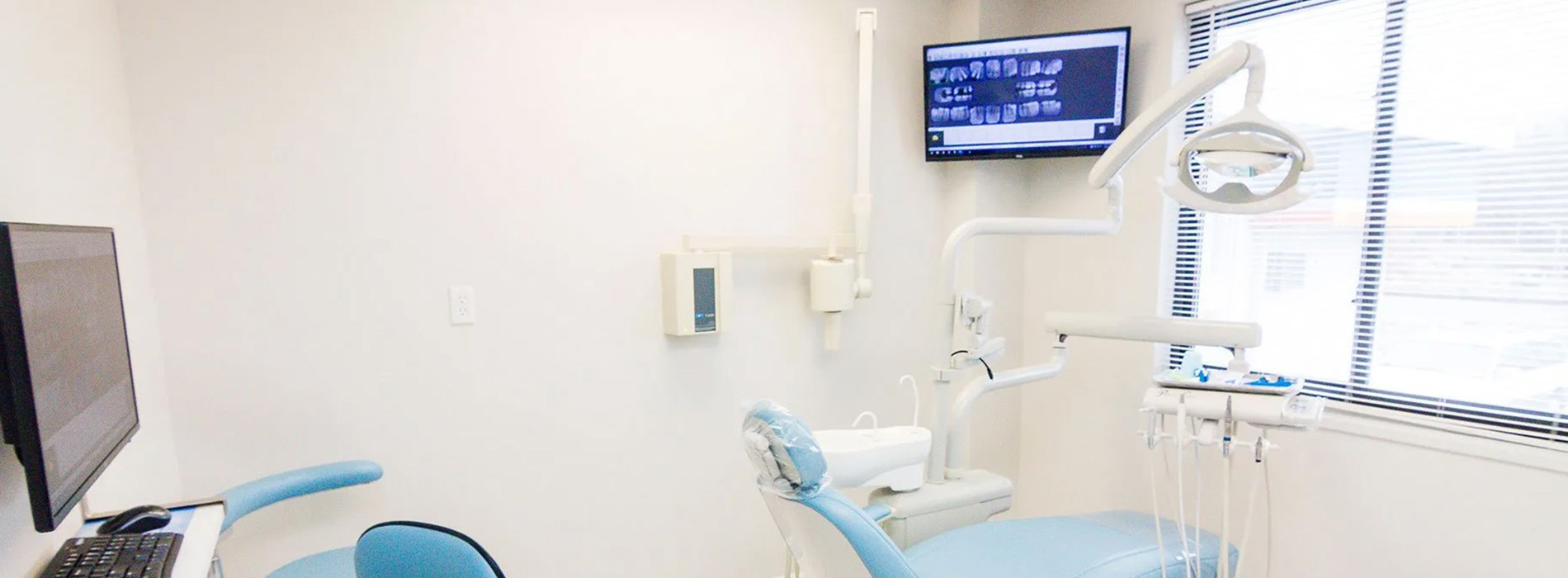 The image shows an interior view of a dental office with a chair in the foreground and dental equipment visible.