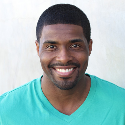 An elderly couple sharing a joyful moment, smiling and embracing each other, with the man wearing glasses and both dressed in casual attire.