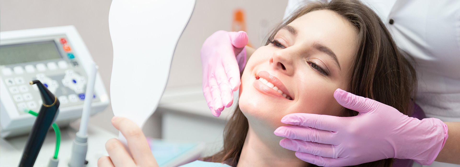 The image depicts a woman sitting in a dental chair, receiving dental treatment with a dentist s hands visible and holding her mouth open.