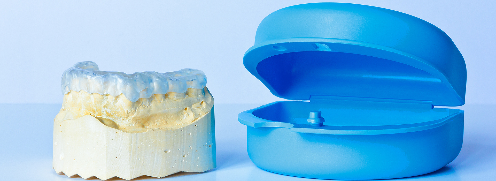 The image features a transparent blue dental impression material alongside an actual dental impression.