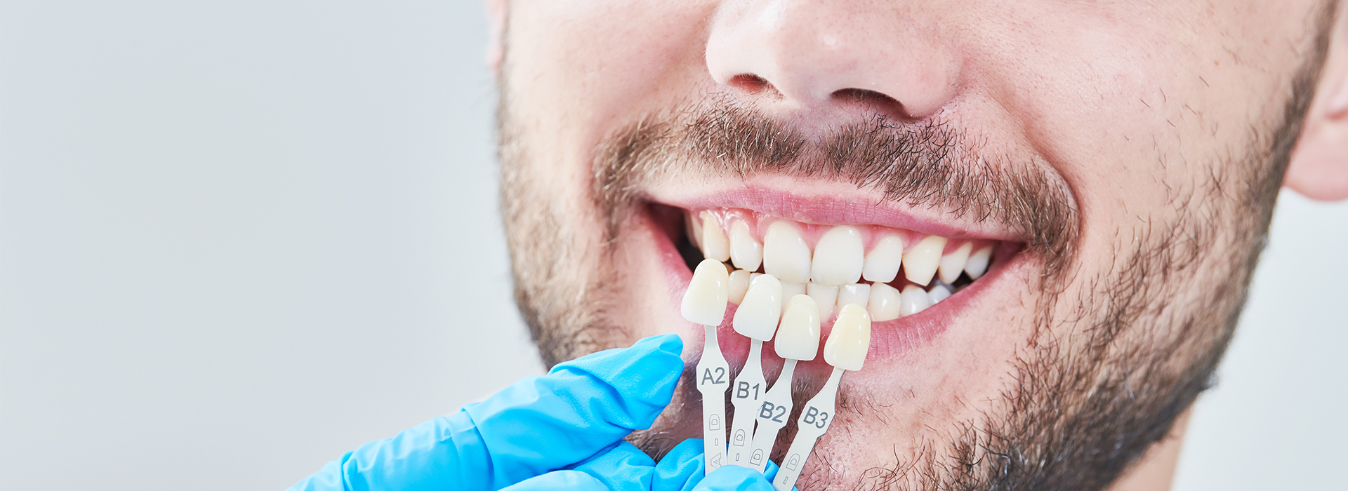 A man in a dental chair receiving treatment with a magnified view of his teeth, showcasing dental work in progress.